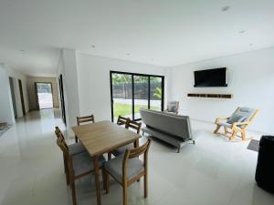 a living room with a table and chairs and a television at Villa Sierra Mar in Playa Bello Horizonte