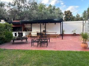 a patio with a table and chairs and a grill at CHACRAS Land in Ciudad Lujan de Cuyo