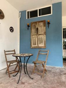 a table and two chairs next to a blue wall at Departamento Luna in Valladolid