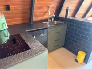 a small kitchen with a sink and a stove at Black Hut in Domingos Martins +17 photos