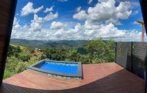 a swimming pool on a deck with a view of the mountains at Black Hut in Domingos Martins