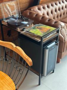 a table with a tv and a chair next to a couch at Black Hut in Domingos Martins