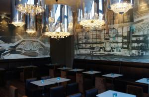 a dining room with tables and chandeliers at Motel One Leipzig-Augustusplatz in Leipzig