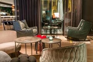 a lobby with chairs and tables in a building at Motel One Freiburg in Freiburg im Breisgau