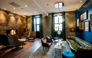 a living room with a couch and chairs and a fireplace at Motel One Magdeburg in Magdeburg +18 photos