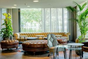 a lobby with a couch and tables and windows at Motel One München-Deutsches Museum in Munich +17 photos