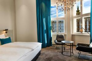 a bedroom with a bed and a table and chairs at Motel One Linz-Hauptplatz in Linz