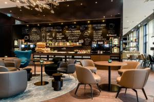 a restaurant with tables and chairs and a bar at Motel One Köln-Altstadt in Cologne