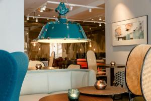a blue chandelier in a restaurant with tables and chairs at Motel One Linz-Hauptplatz in Linz