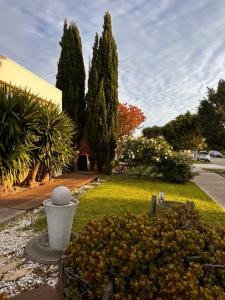a garden with trees and a statue in a yard at Exclusive B and B room in Lyndhurst