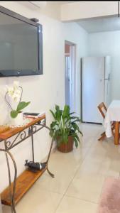 a living room with a flat screen tv on a wall at Hospedaria Klagemberg in Treze Tílias