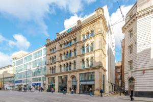 a building on a street with people walking in front of it at Motel One Manchester-Royal Exchange in Manchester