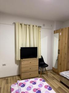a living room with a tv and a bedroom at gvero apartment’s in Prilep