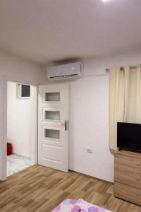 a room with a white door and a tv and a room at gvero apartment’s in Prilep