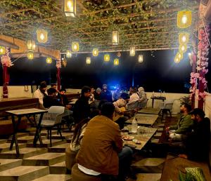 a group of people sitting at tables in a room at Yatram in Rishīkesh