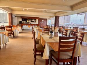 a dining room with tables and chairs and windows at Gran Hotel Ica in Ica