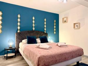 a bedroom with a large bed with blue walls at La Bastide in Carcassonne
