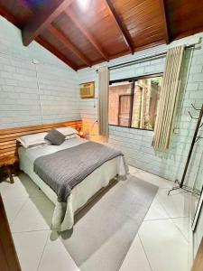 a bedroom with a bed and a large window at Sítio Harmonia! in Harmonia