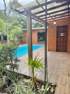 a swing in front of a house with a swimming pool at Sítio Harmonia! in Harmonia +27 photos