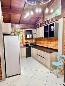 a kitchen with a white refrigerator and a blue chair at Sítio Harmonia! in Harmonia