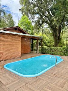 a large blue swimming pool in front of a house at Sítio Harmonia! in Harmonia