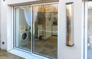 a glass window of a kitchen with a washing machine at Studio Tout Confort in Fondettes +11 photos