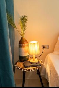 a table with a lamp and a vase on it at Bali-Inspired Studio Mins from Airport in Arima +14 photos