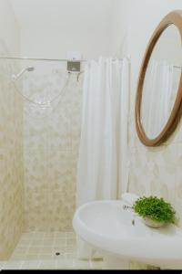 a bathroom with a white sink and a mirror at Bali-Inspired Studio Mins from Airport in Arima