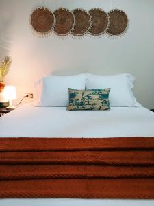 a bed with white sheets and two pillows on it at Bali-Inspired Studio Mins from Airport in Arima