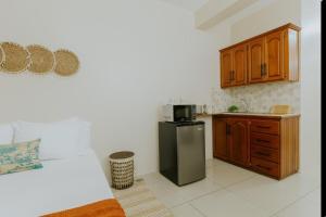 a kitchen with a stainless steel refrigerator and wooden cabinets at Bali-Inspired Studio Mins from Airport in Arima