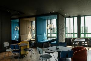 a restaurant with tables and chairs and windows at Motel One Mannheim in Mannheim +22 photos