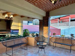 a patio with two benches and a table and chairs at Hotel-Posada Kali Tlayacapan in Tlayacapan