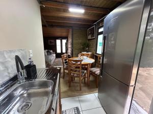 a kitchen with a stainless steel refrigerator and a table at Casa Aconchegante in Pomerode
