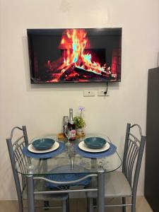 a glass table with two chairs and a fireplace at Haven's Suites a place like home in Manila
