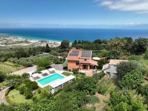 an aerial view of a house with a swimming pool and the ocean at Villa Zufrò in Vibo Valentia