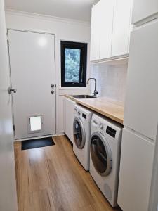 a kitchen with a sink and a washing machine at Moonlight Ridge Chalet in Merrijig