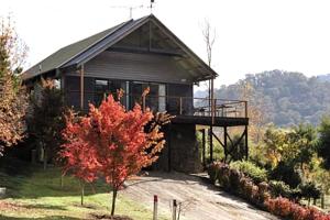 a house with a balcony on the side of it at Moonlight Ridge Chalet in Merrijig