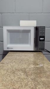 a microwave oven sitting on top of a counter at Quarto Familiar Próximo ao Aeroporto de Guarulhos in Guarulhos