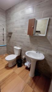 a bathroom with a white sink and a toilet at Quarto Familiar Próximo ao Aeroporto de Guarulhos in Guarulhos