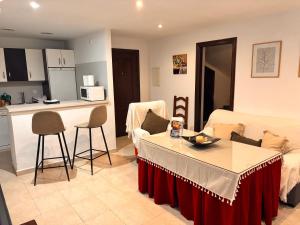 a living room with a couch and a table and a kitchen at Apartamento La alberca 1 in Aracena