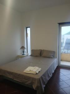 a bedroom with a bed with two towels on it at Centro Da Vila in Lourinhã