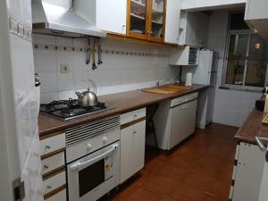 a kitchen with white cabinets and a stove top oven at Centro Da Vila in Lourinhã
