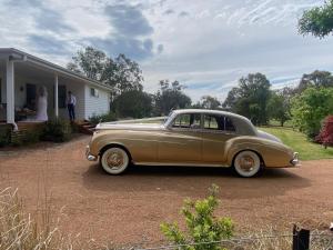 an old car parked in front of a house at Grevillea Cottage in Murrumbateman