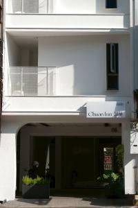 a white building with a sign that reads gillian inn at Chuan Inn圈旅 站前館 in Tainan