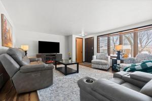 a living room with couches and a flat screen tv at Three Bedroom Ranch walking distance to Lambeau in Green Bay