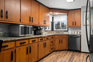 a large kitchen with wooden cabinets and a sink at Three Bedroom Ranch walking distance to Lambeau in Green Bay