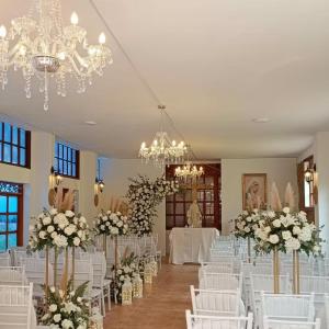 a room filled with white chairs and tables with flowers at Hotel Bosque de la Villa in Villa de Leyva +23 photos