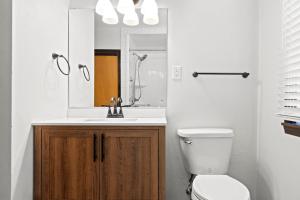 a bathroom with a toilet and a sink and a mirror at Three Bedroom Ranch walking distance to Lambeau in Green Bay +56 photos