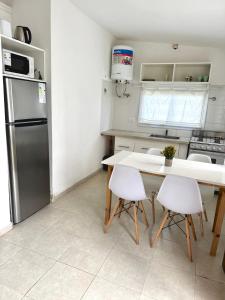 a kitchen with a table and chairs and a refrigerator at Casa de 2 dormitorios, zona parque in Necochea
