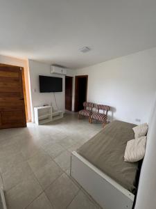 a bedroom with a bed and a flat screen tv at Casa de 2 dormitorios, zona parque in Necochea